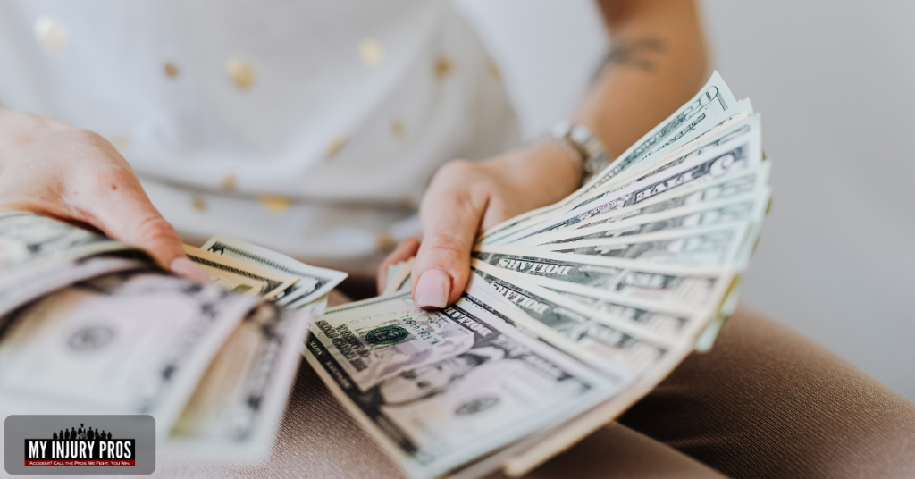 Person holding cash to illustrate taxable portions of a settlement in the guide Do I Have To Report Personal Injury Settlement To IRS.