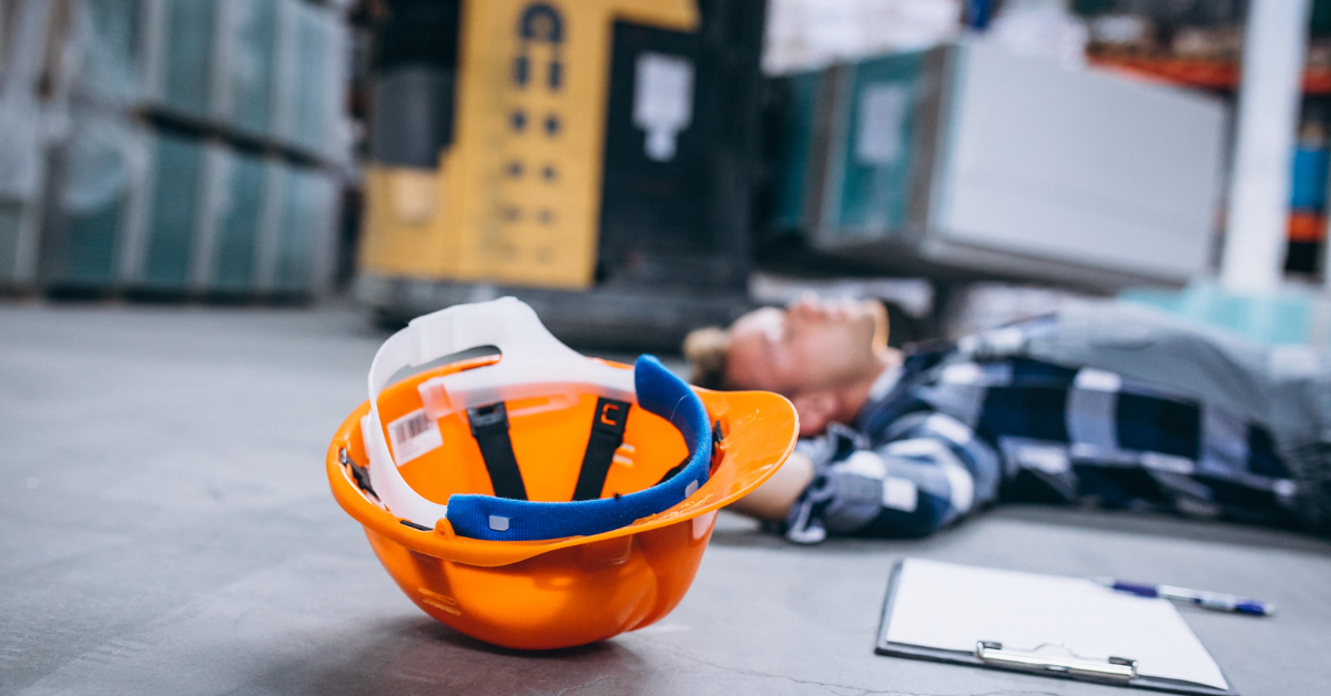 Trabajador lesionado en un accidente de construcción con casco de seguridad en el suelo