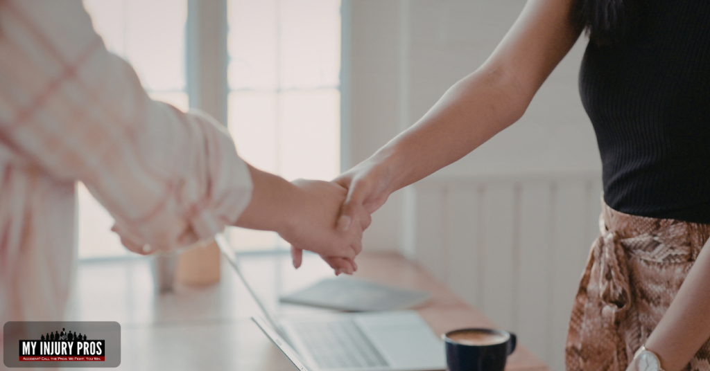 Cliente estrechando la mano de su abogado tras un caso de accidente de viaje compartido